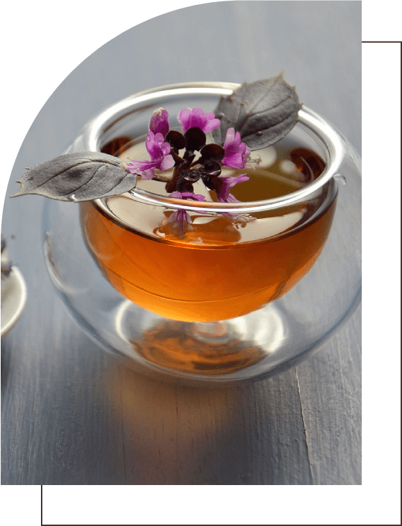 A cup of tea with purple flowers in it.