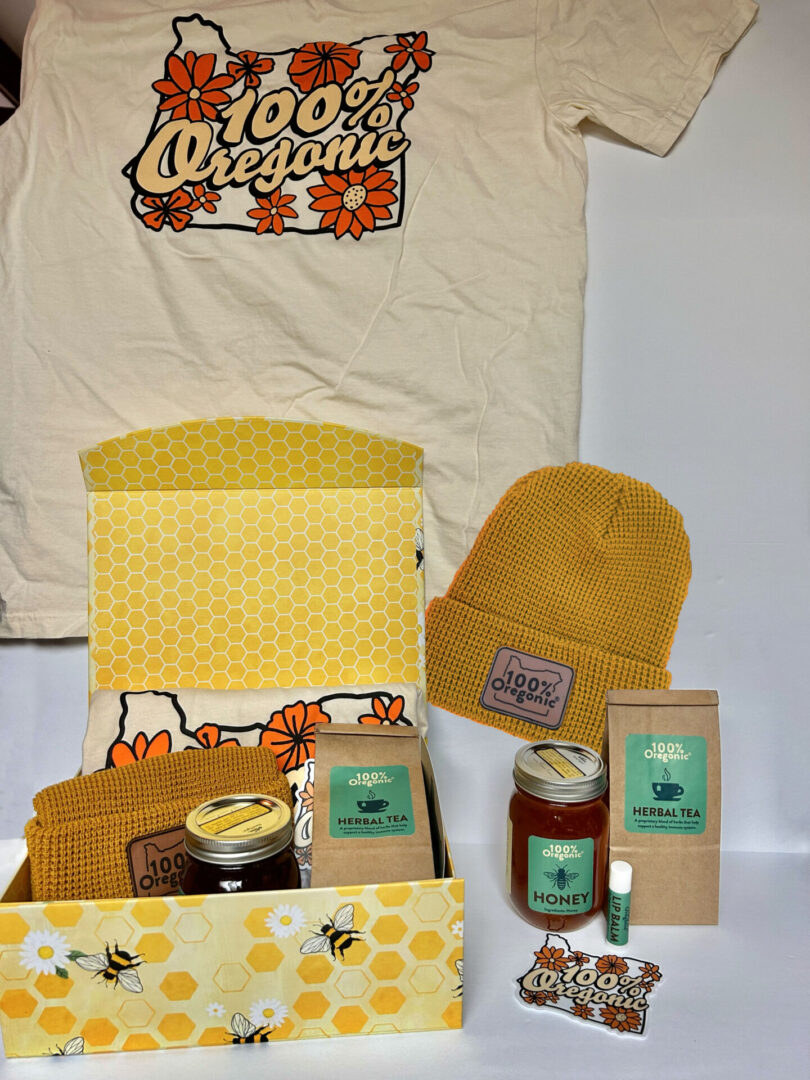 A 100% Oregonic Gift Box with a t - shirt, bees, and other items.